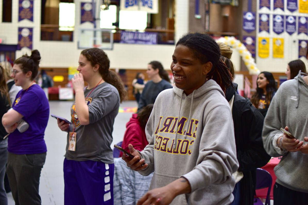 A female student laughs at one of the Elmira College Dance Marathon activities as other students around her look on
